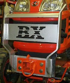 the front end of an orange and black tractor with lights on it's headlight