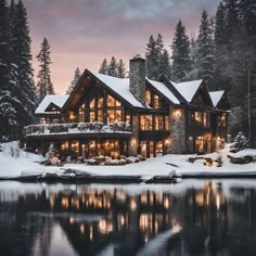 a large house sitting on top of a lake covered in snow next to evergreen trees