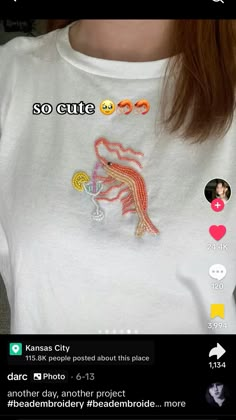 the woman is wearing a white shirt with an embroidered dragon on it's chest