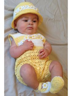 a baby wearing a yellow outfit and hat