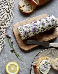 a loaf of bread with flowers on it next to sliced lemons and slices of bread