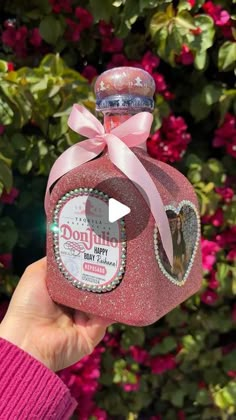 someone is holding up a pink bottle with a bow on it's neck and the label says donutle happy birthday