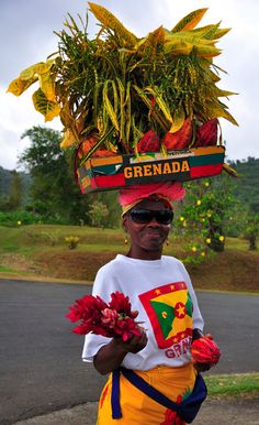 a woman with flowers on her head walking down the street in front of some trees