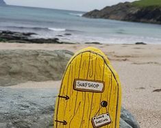 a yellow door sitting on top of a beach next to the ocean