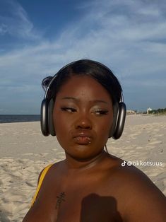 a woman wearing headphones on the beach