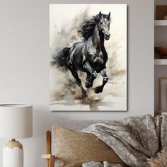 a black horse running in the wind on a white wall above a couch with pillows