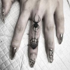 a woman's hand with a spider tattoo on it