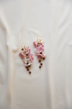 A beautiful one of a kind handmade pair of earrings. These earrings have cherry blossom flowers, white petals, pink pearls, fresh water pearls and garnet beads all clustered together to make a statement piece! only one available.  D E T A I L S - 14k gold filled hook  - cherry blossom glass blown beads  - small white floral accents  - garnet beads  - pink genuine pearls  - white genuine freshwater pearls  - 14 gold filled accents. stamped  - Earring hook is gentle on the ears and feels secure.  ∙ EXTRAS  - Handcrafted with a lot of love.  - All of my jewelry arrives tightly wrapped.  - If this is a special gift or if you would like a customization just let me know in the message box at checkout.  ∙ MY SHOP Check out more of my pieces - https://www.etsy.com/shop/ashlikitta?ref=simple-shop-h Cherry Blossom Earrings, Pink Flower Earrings, Stamped Earrings, White Petals, Pink Pearls, Someday My Prince Will Come, Cherry Blossom Flowers, Flowers White, Garnet Earrings