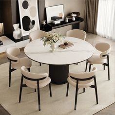 a dining room table with chairs around it and a vase on the table next to it