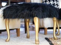 two gold legs with black fur on them in front of a white chair and rug