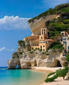 an image of a beautiful beach scene with houses on the cliff and clear blue water