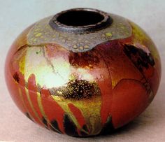 a red and yellow vase sitting on top of a table