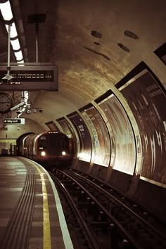 a subway train pulling into the station with its lights on