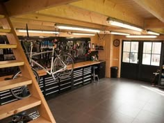 a bike is hanging from the ceiling in a garage with stairs leading up to it