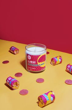 a candle sitting on top of a yellow table next to candy candies and confetti