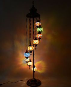 a multicolored lamp is lit up on a stand with many lights around it