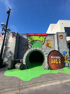 the entrance to an amusement park with graffiti on it