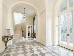 an entry way with a checkered floor and chandelier