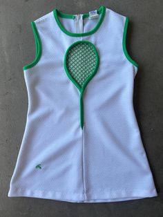 a women's white and green tennis top with a racket on the front