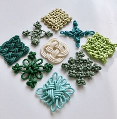 six different colored crochet designs on a white surface with one knot in the middle