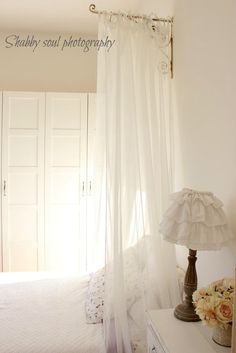 a bedroom with a white bed and curtains