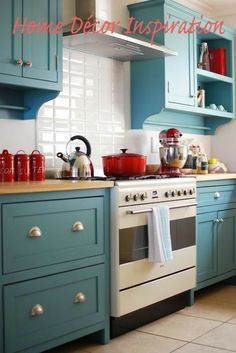 a kitchen with teal cabinets and white stove top oven in the middle of it