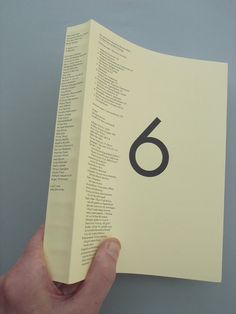 a hand is holding an open book with the number six on it's cover