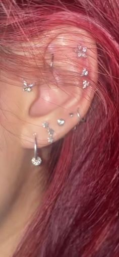 a woman with red hair and piercings on her ear