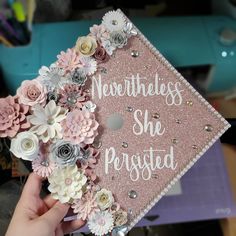 someone is holding up a graduation cap with flowers on it that says, nevertheless she forgot