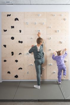 two children are climbing on the wall together