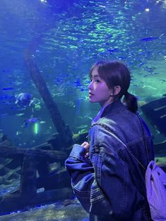 a woman standing in front of an aquarium