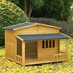 a small wooden dog house in the middle of leaves