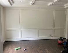 an empty room with hard wood floors and white paneling on the walls is shown