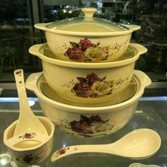 a glass table topped with bowls and spoons filled with soup or cereal bowl covered in floral designs