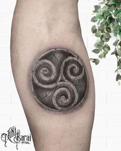 a black and white photo of a tattoo design on the leg, with spirals in it