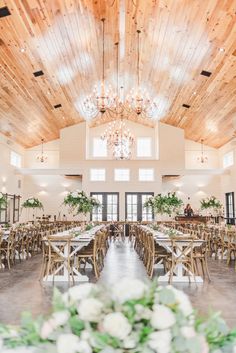 a large room with tables and chandeliers in it