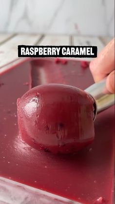 someone is using a sharp knife to cut the cranberry caramel