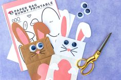 paper bag bunny printables and scissors on a blue background with crafting supplies