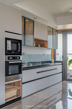 a modern kitchen with stainless steel appliances and marble counter tops, along with large sliding glass doors