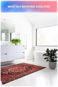 a bathroom with a rug, sink and bathtub next to a large window on the wall