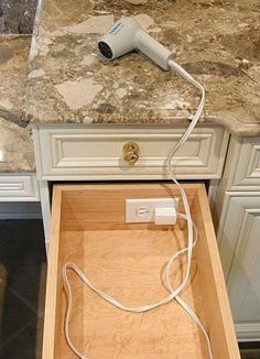 an electrical outlet is plugged into a drawer in a kitchen with marble countertops