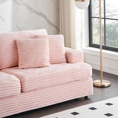 a pink couch in front of a large window