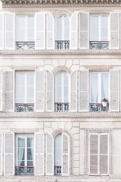 an apartment building with white shutters and balconies