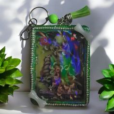 a keychain with an image of a woman in green and blue on it