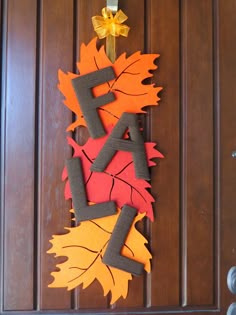 an autumn door hanger made out of felt with leaves and the word fall on it