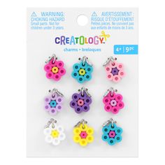 six different colored buttons with flowers on them in a card board package for crafting