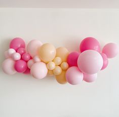 a bunch of balloons that are in the shape of letters m and w on a white wall