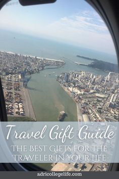 an airplane window with the words travel gift guide on it, and a view of a city