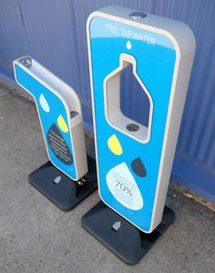 two water dispensers sitting next to each other on top of a sidewalk