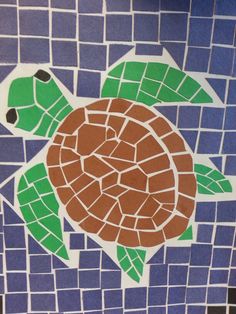 a turtle painted on the side of a blue and white tile wall with green leaves